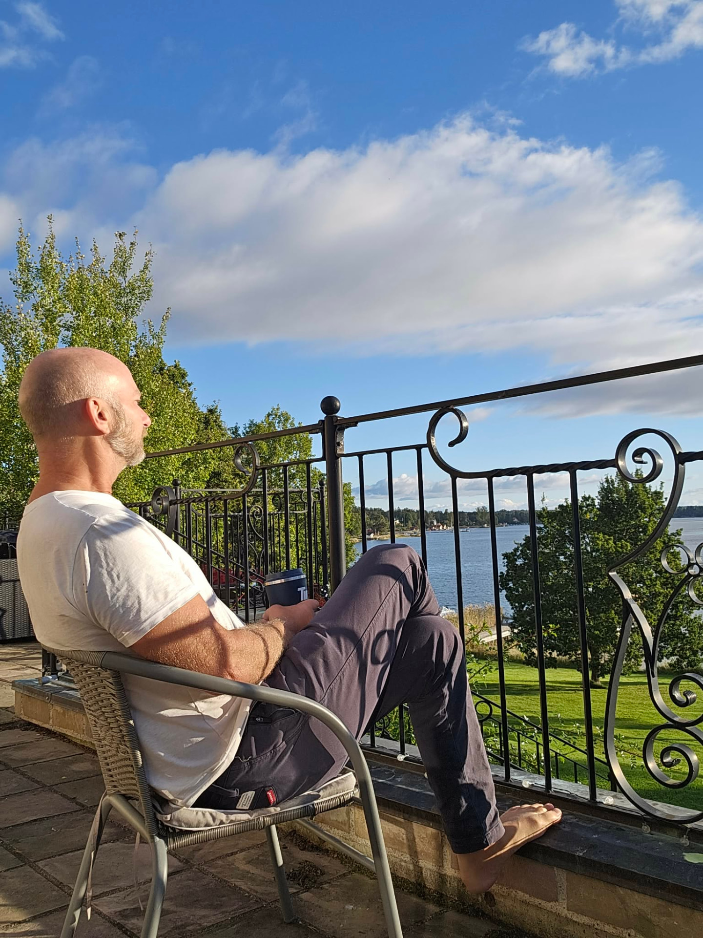 Mathias Ringblom sitter på en balkong och blickar ut över vatten och grönska